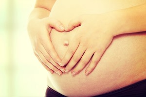 Pregnant woman with hands on belly 300x200